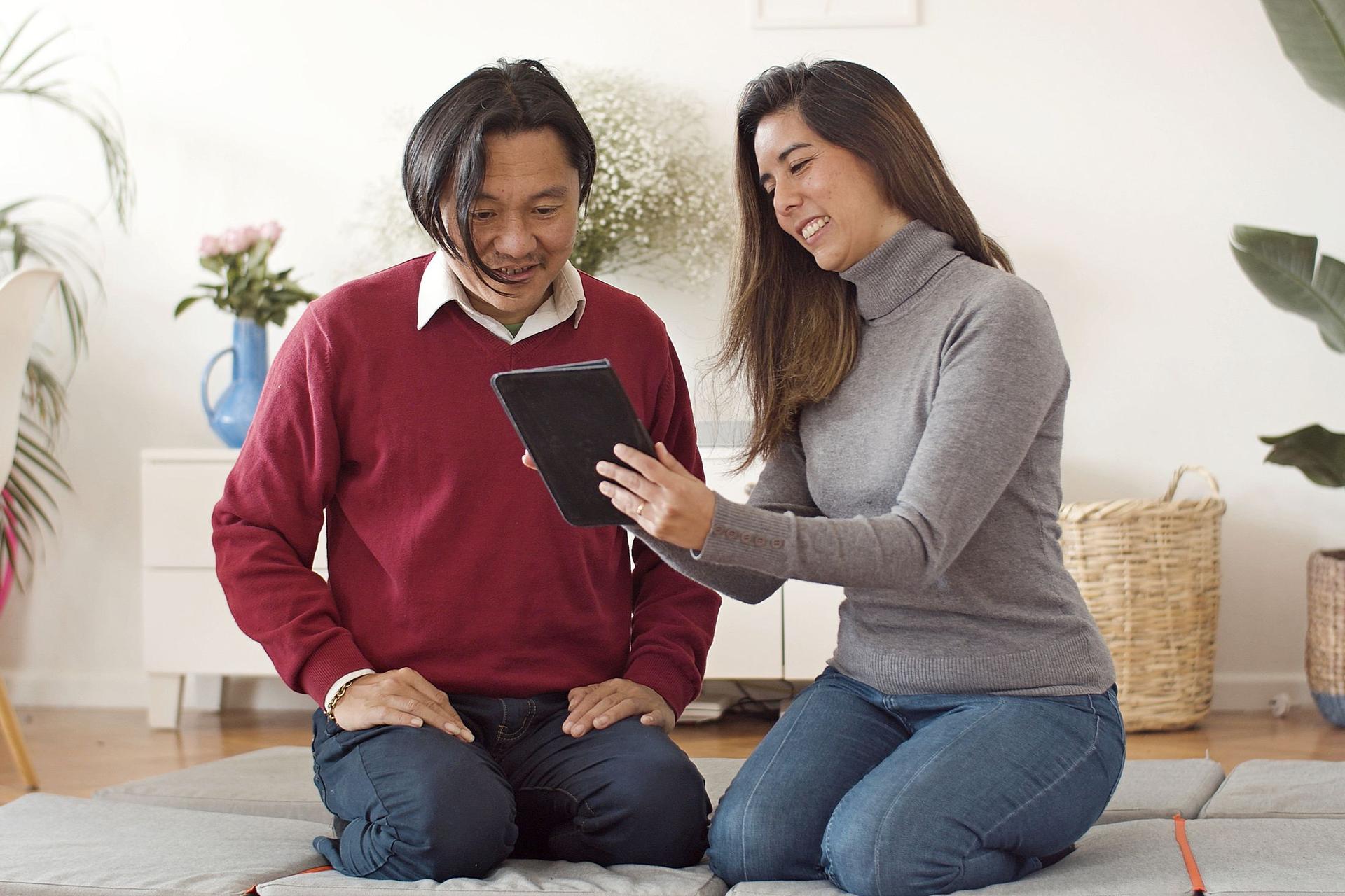 An overseas couple browses a development on a tablet at home